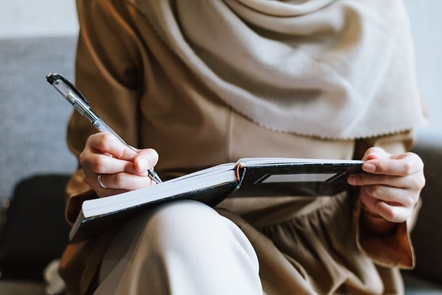 a hand writing in a notebook